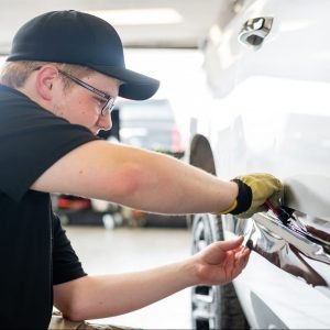 employee installs vinyl wrap on a vehicle