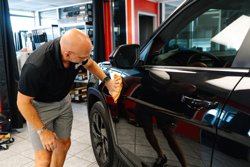 Man wiping car with microfiber